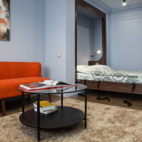 studijas tipa dzīvoklis ar gultas un dīvāna interjera foto