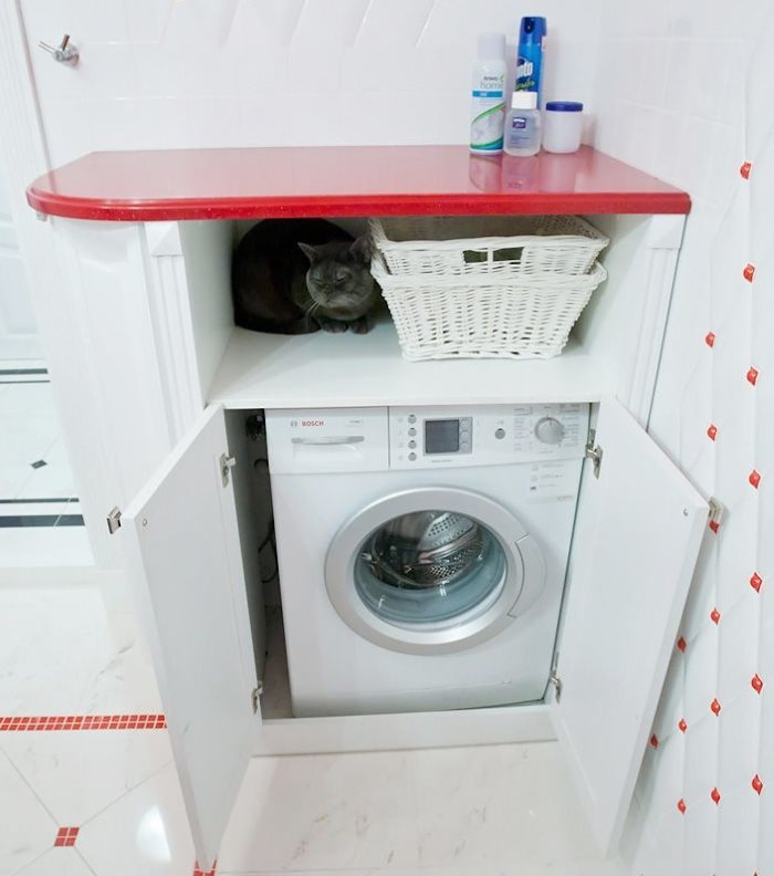 Red shelf over the washing machine in the bathroom