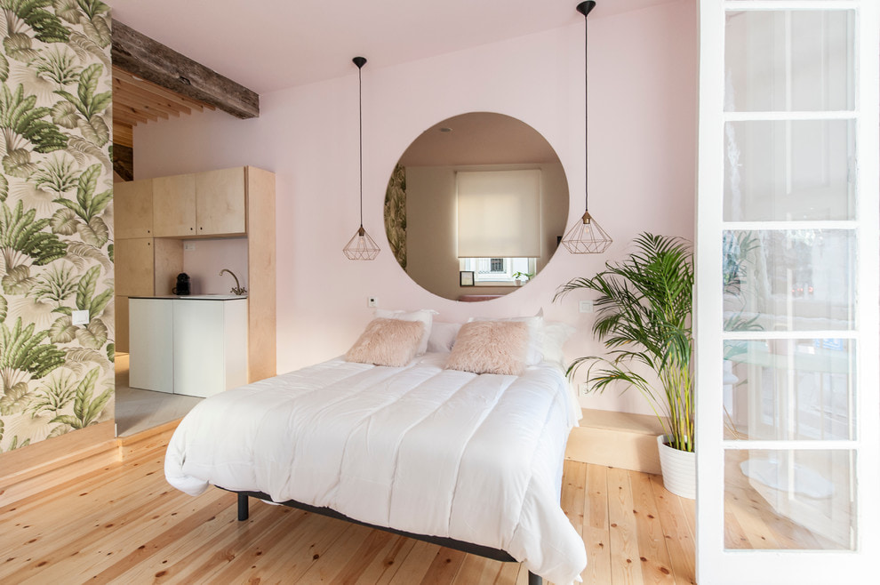 Balta gultas pārklāja rozā guļamistabas sienā