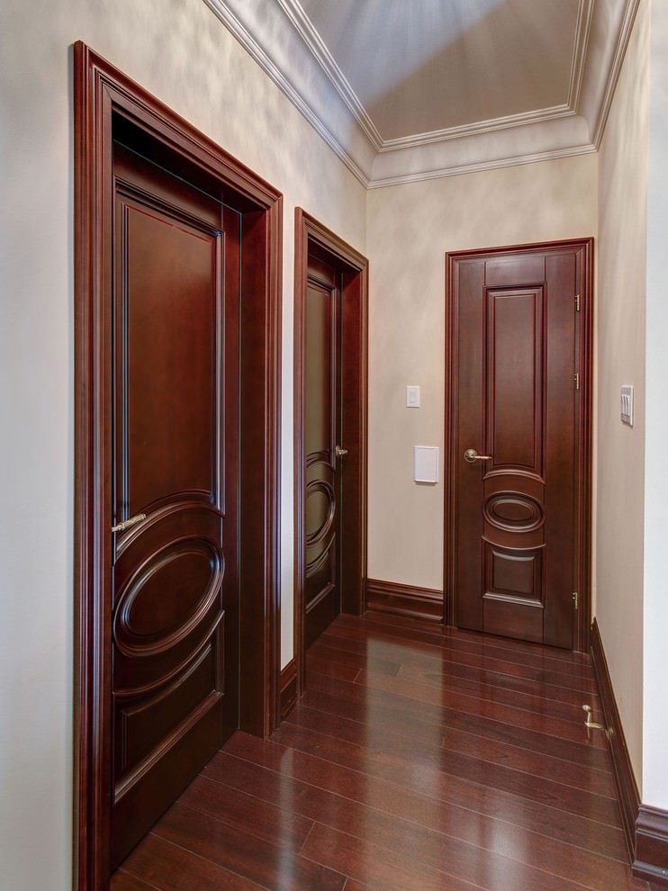 Ciemne drewniane drzwi w wąskim korytarzu mieszkania
