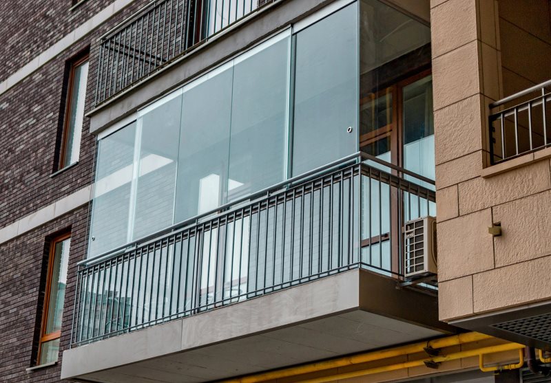 Beglaasd balkon op de gevel van een gebouw met meerdere verdiepingen