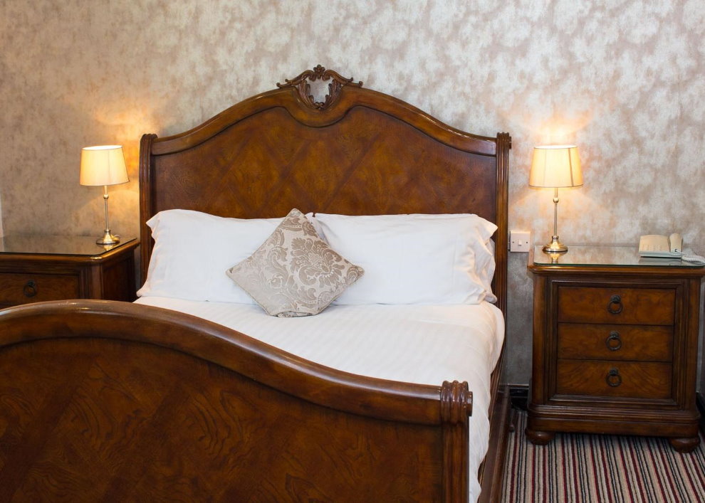 Koka gulta angļu stila guļamistabā
