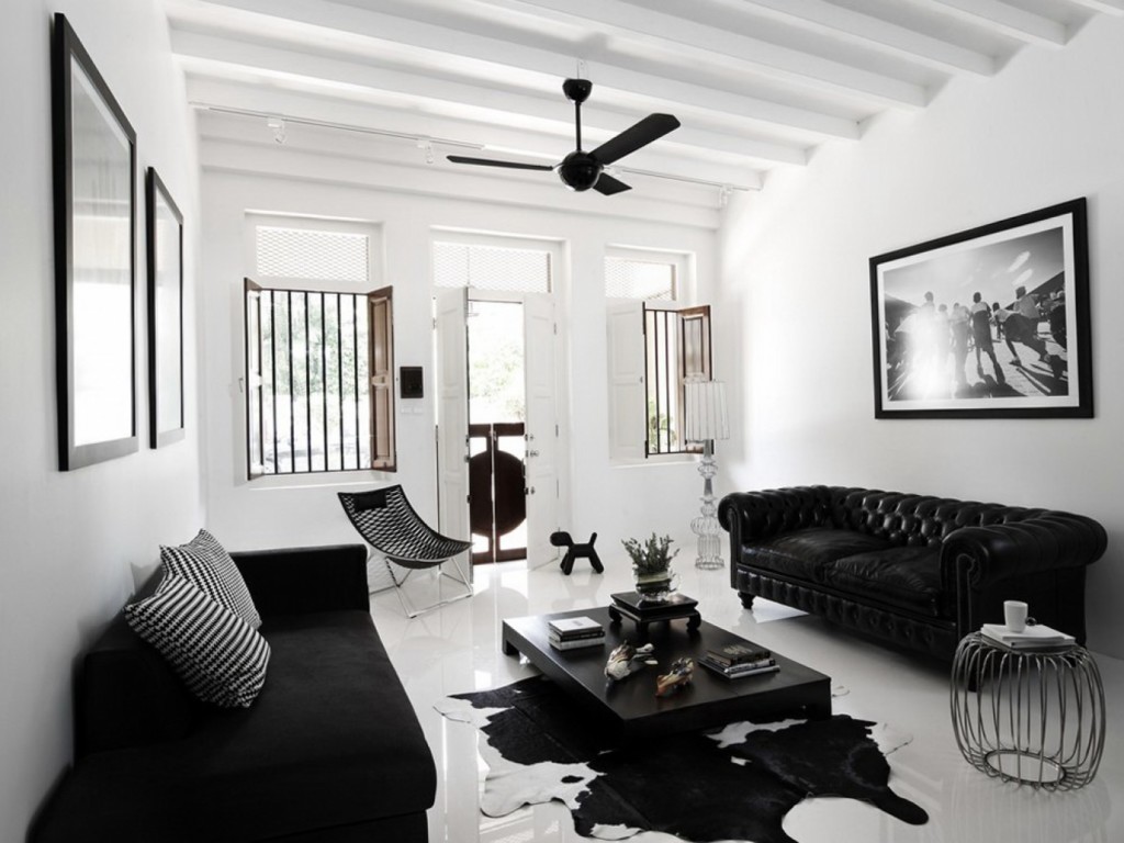 Travi bianche sul soffitto del soggiorno con divano nero
