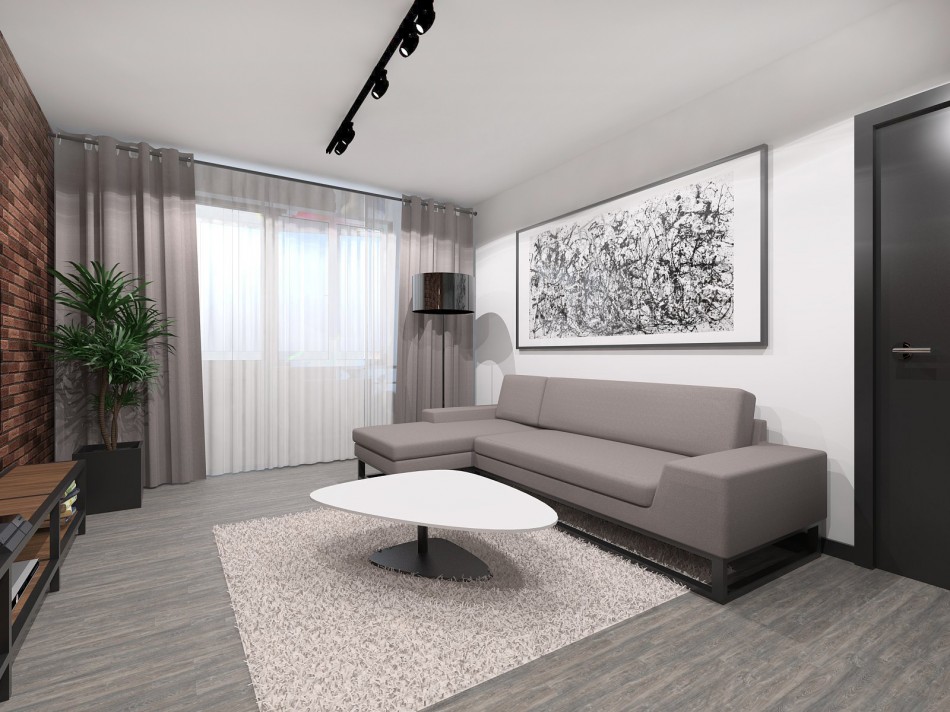 Graues Sofa gegen eine weiße Wand in einer Studiowohnung