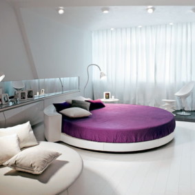 Purple bedspread on a round bed