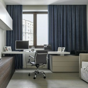Desk by the window with dark curtains
