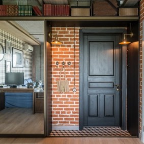 Porte noire avec panneaux dans un couloir de style loft