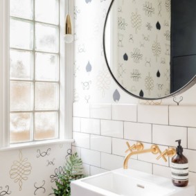 Round mirror above the washbasin in the bathroom