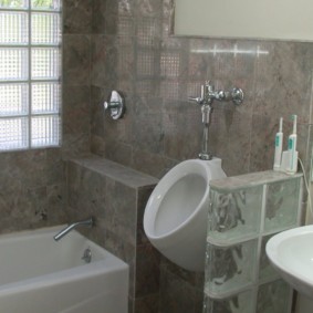 Gray tile on the wall of the combined bathroom