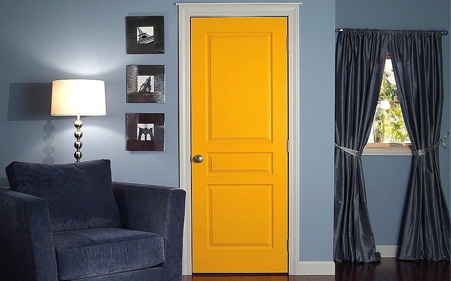 Bright yellow door in a room with black curtains
