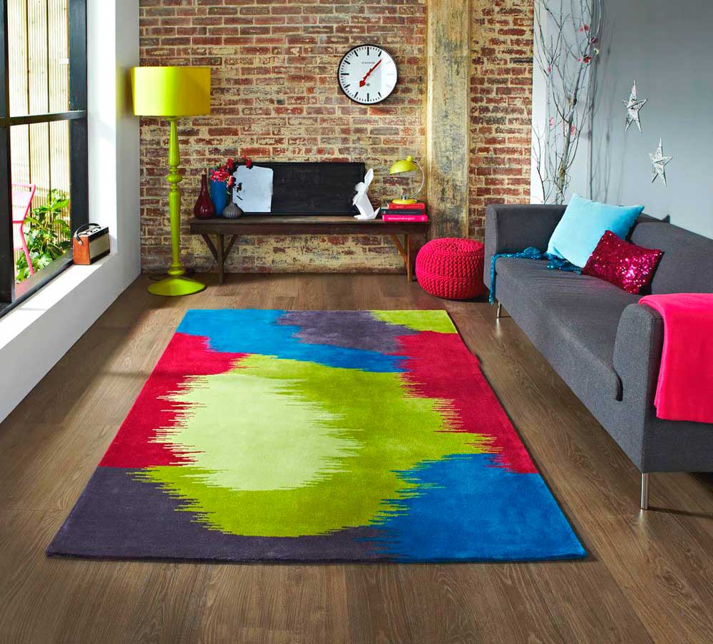 Jasny dywan przed szarą sofą w salonie