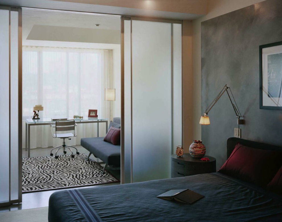 Glass sliding partition in the bedroom with an office