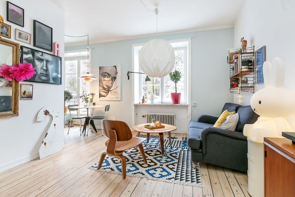 Gaišs dekors studijas tipa dzīvoklī ar baltām sienām