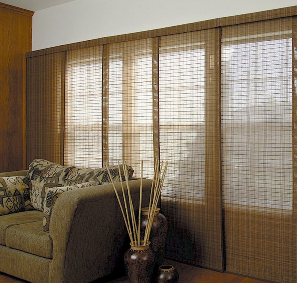 Skjut bambu gardiner på vardagsrummet bakom soffan
