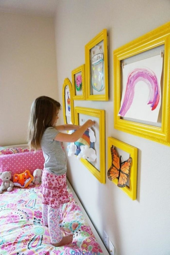 Fată care decorează un perete peste patul ei