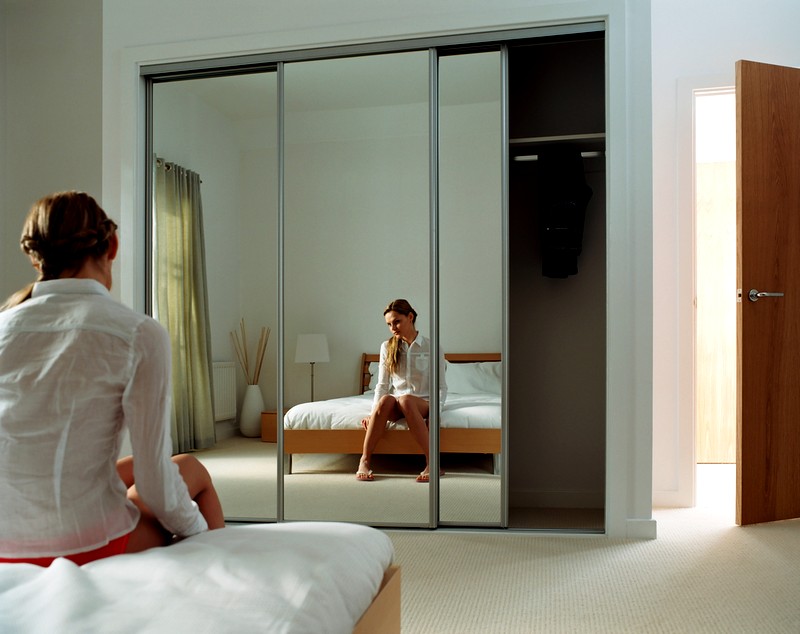 Reflexion av en flicka i ett spegelskåp i ett sovrum