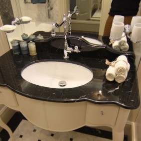 Handfat med svart bänkskiva i badrummet i ett privat hus