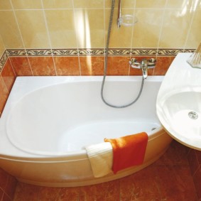 Oranžový uterák na boku kúpeľne