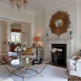 Gold-framed mirror above the fireplace in the living room
