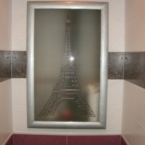 Puerta de cristal de un armario oculto en la pared del inodoro.