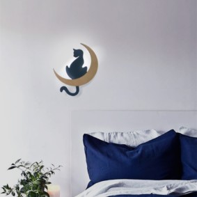 Lumină de noapte montată pe perete cu o pisică pe o lună semilună