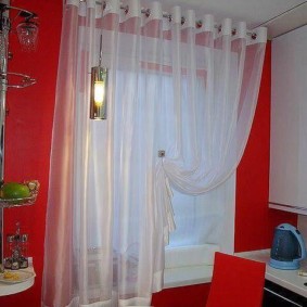 Hvitt gardin på kjøkkenet med en rød vegg