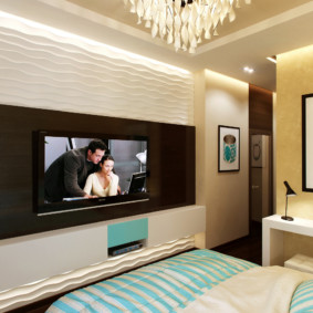 Interiören i ett litet sovrum med en TV på väggen