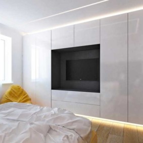 Spavaća soba minimalističkog stila sa tv-om u niši