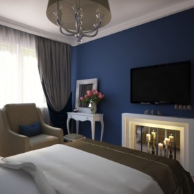 Ciemnoniebieska ściana w małej sypialni
