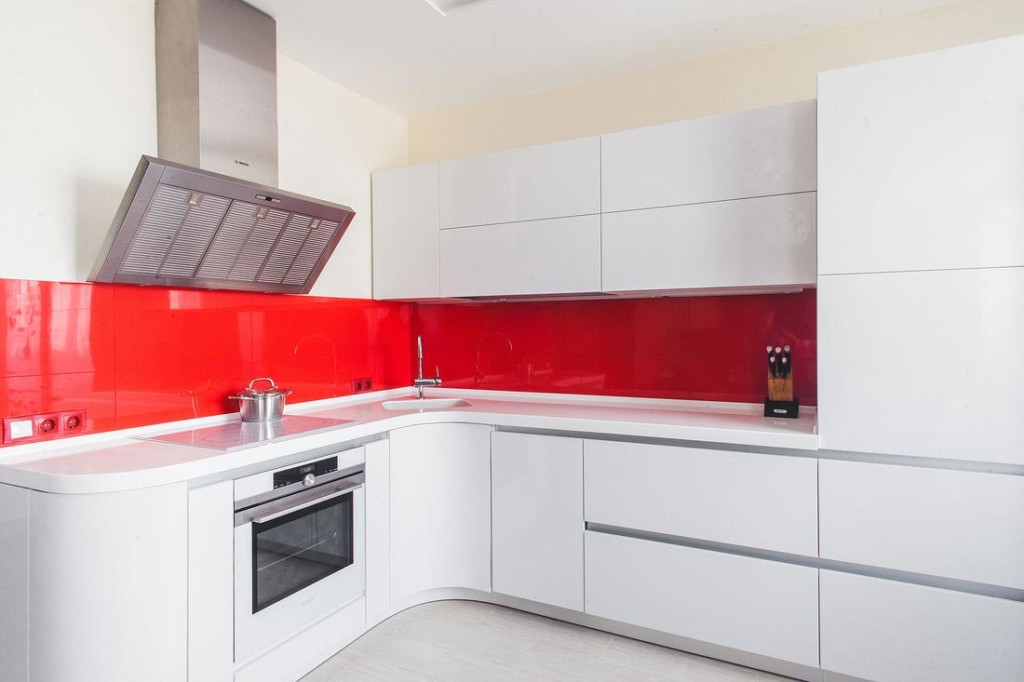 Červená zástera v kuchyni s umývadlom na rohu