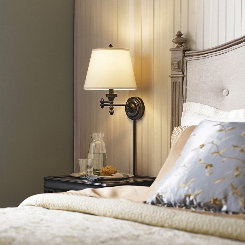 Retro lampka nocna nad łóżkiem w sypialni w stylu wiejskim