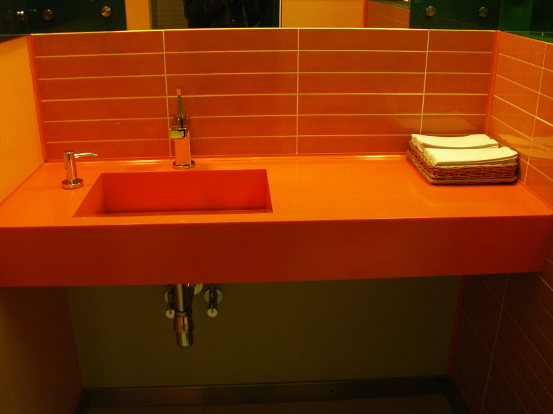 Orange tile sa itaas ng countertop sa banyo