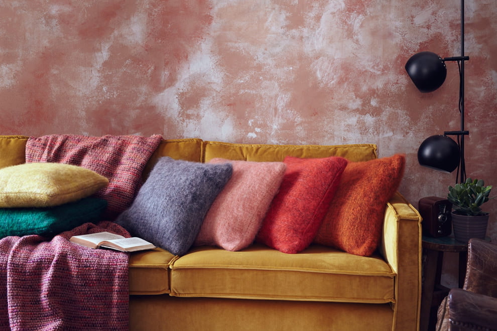 Sinepju dīvāns viesistabā ar persiku sienām