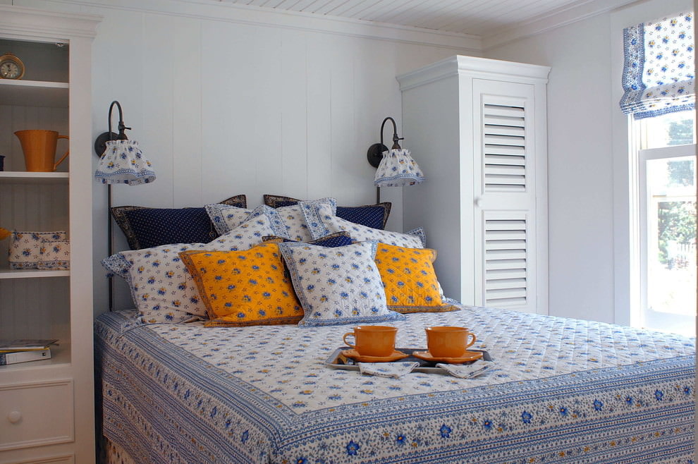 Litet sovrum i Provence-stil med blommiga textilier