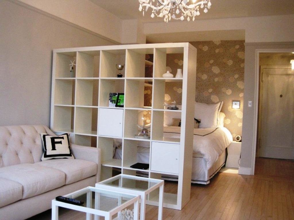 White shelving in the living room with a bed