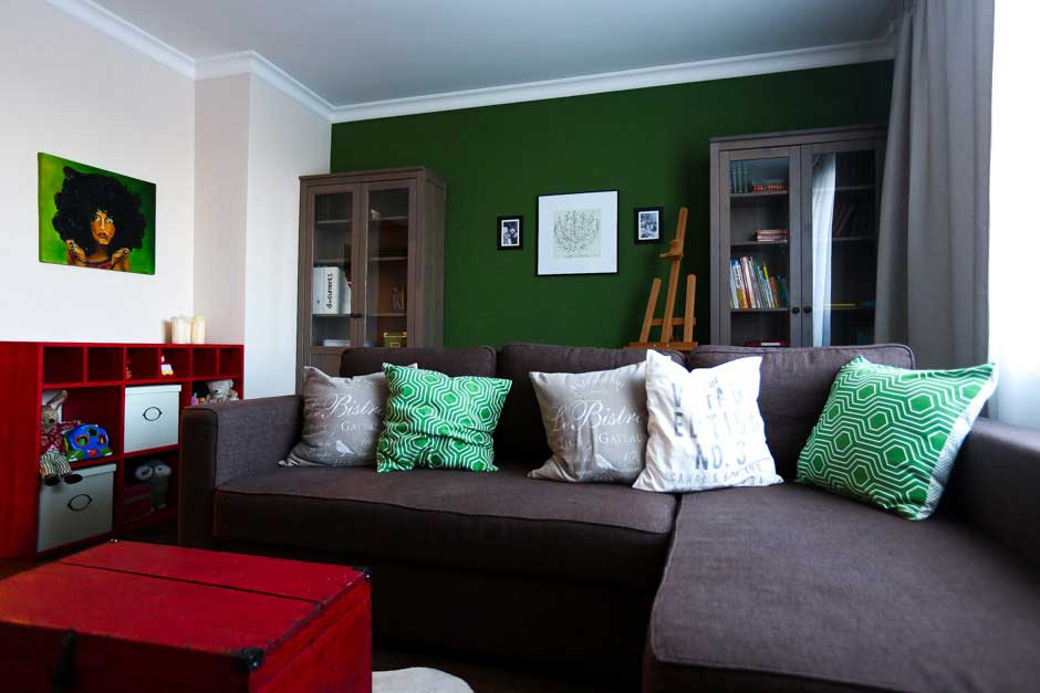 The accent wall of the living room is dark green