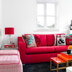 Červený nábytok v bielej obývacej izbe