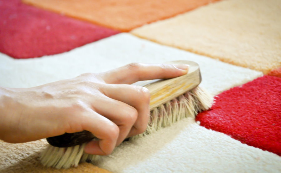 Brushing a carpet in a nursery