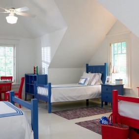 Červené a modré postele v prostorné místnosti