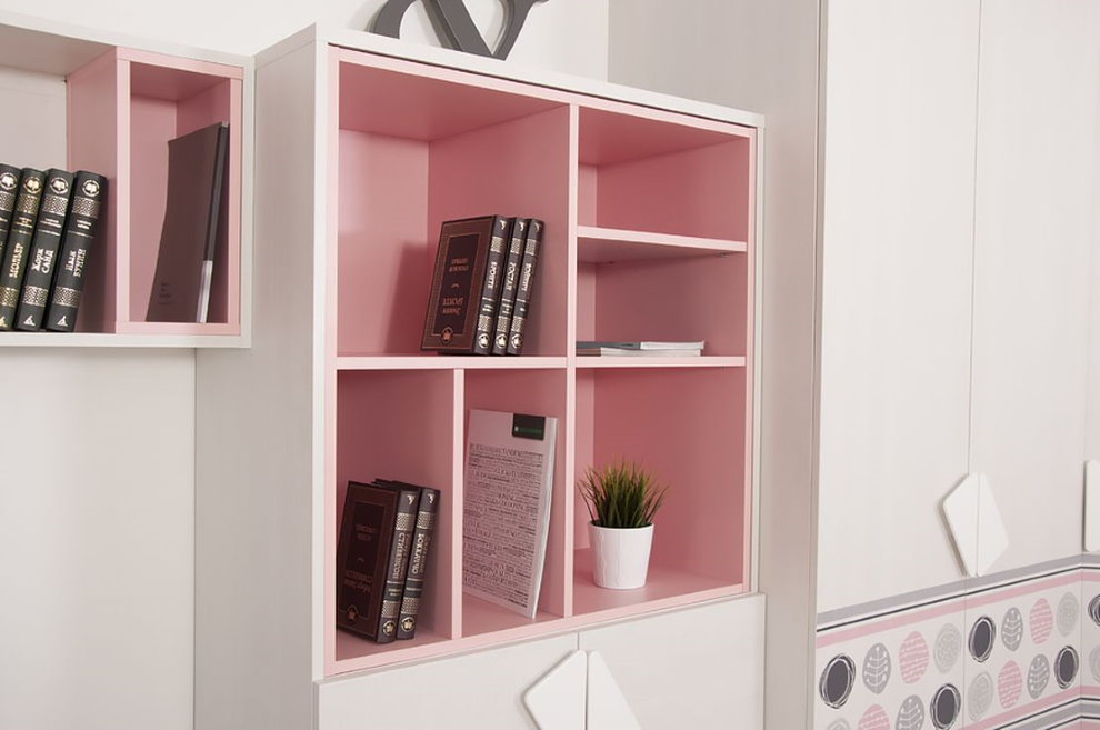 Rózsaszín polcok belsejében egy gyermek könyvespolc
