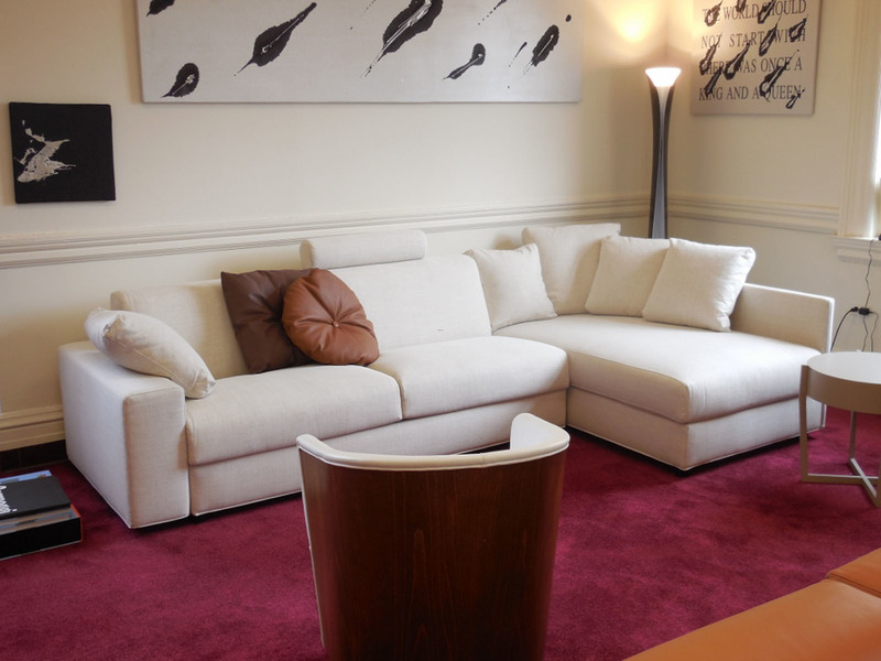 Burgundy carpet sa harap ng isang puting sofa