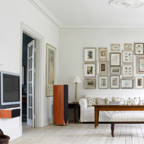 Tauriņu kolekcija uz viesistabas baltas sienas