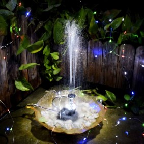 Liten fontene med dekorativ belysning