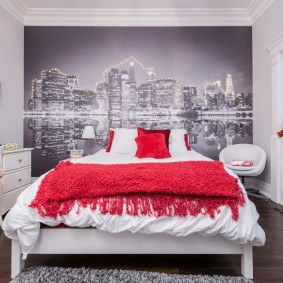 Sarkans gultas pārklājs uz baltas gultas