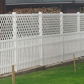 Yakacak odun beyaz bir çit arkasına döken