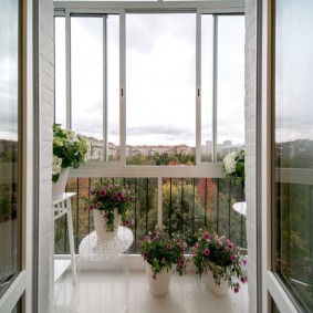 Atveriet durvis uz balkona ar ziediem