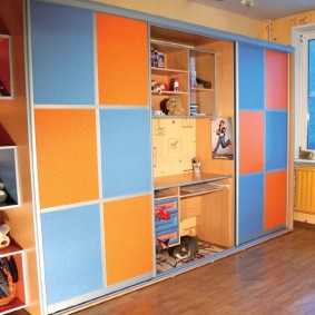 Sliding wardrobe with a built-in table in the children's room