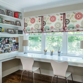 Workplace for two children in front of the room window