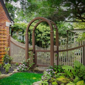 Houten pergola boven de poort in de tuin