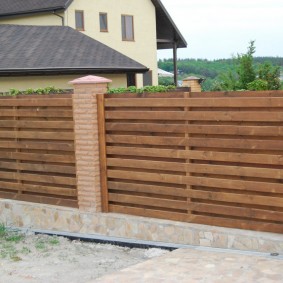 Finishing the base of the fence with natural stone